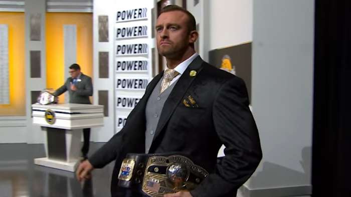 NWA champion Nick Aldis makes his entrance carrying the title belt
